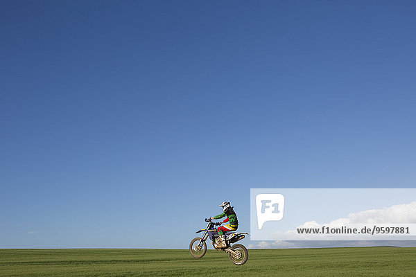 Junger männlicher Motocross-Rennfahrer auf dem Feld