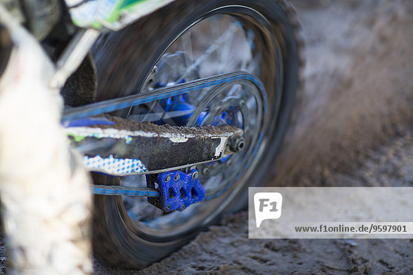 Nahaufnahme eines Motocross-Motorrads  das sich im Schlamm dreht