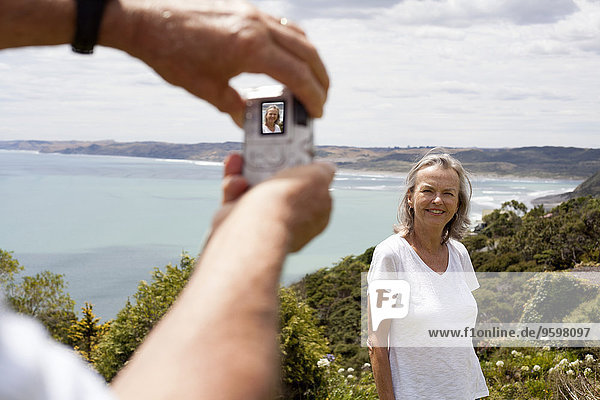 Ehemann fotografiert Frau  Ozean im Hintergrund  Raglan  Neuseeland