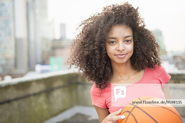 Junge Frau hält Basketball