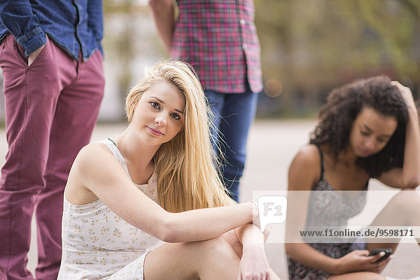 Portrait of young woman with friends in park