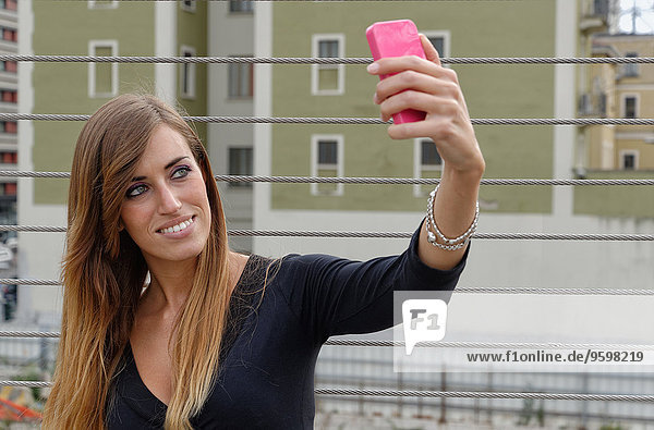 Junge Frau beim Selbstporträt mit dem Smartphone