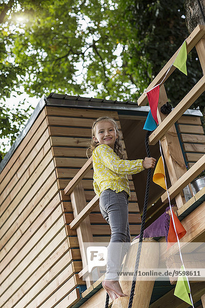 Mädchen kommt vom Baumhaus herunter
