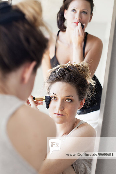 Young women applying make-up