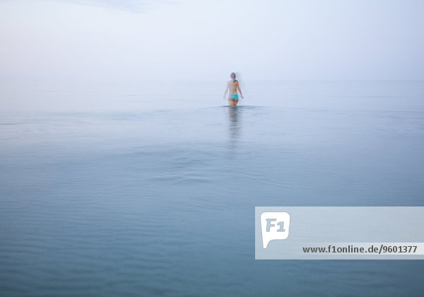Frau läuft ins Meer  Bewegungsunschärfe