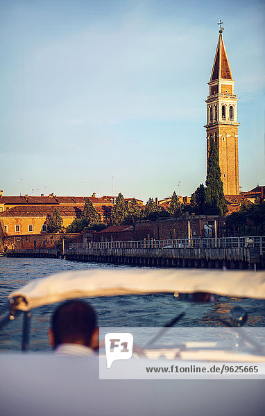 Italien,  Venedig,  Boot und Fahrer mit St. Mark's Campanile im Hintergrund
