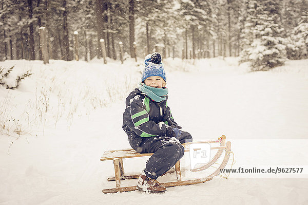 Germany  Bavaria  Berchtesgadener Land  happy boy on sledge