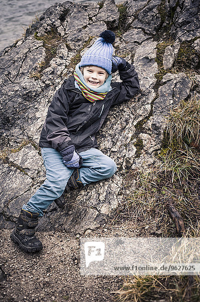 Germany  Bavaria  Ramsau  smiling boy on rock