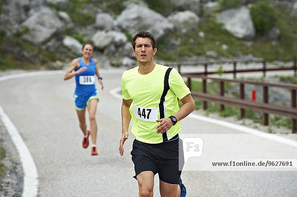 Italy  Trentino  man and woman running in a competition near Lake Garda
