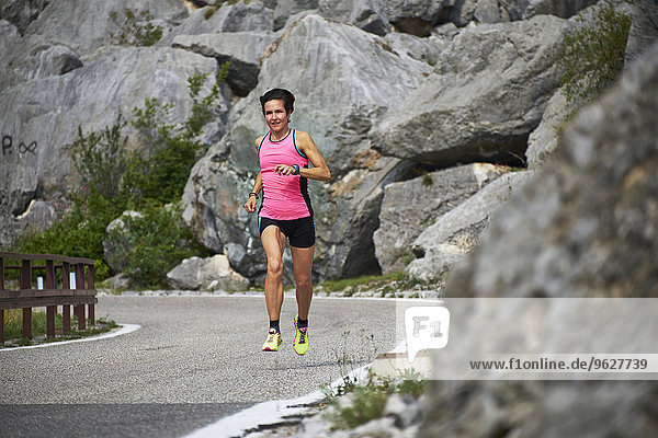 Italy  Trentino  woman running on road near Lake Garda