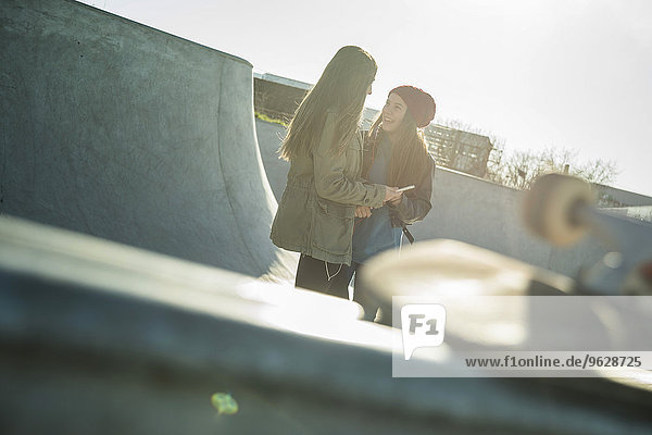 Zwei Teenager-Mädchen im Skatepark beim Reden