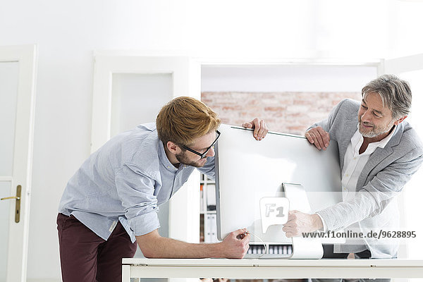 Zwei Männer im Büro verbinden Computerbildschirm