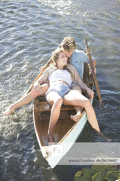 Verspieltes junges Paar in einem Ruderboot auf einem See