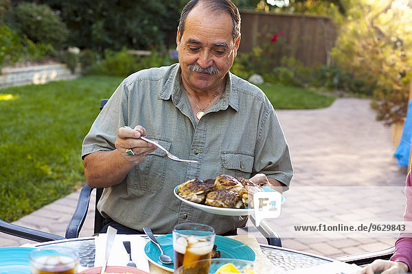 Mann beim Essen im Garten