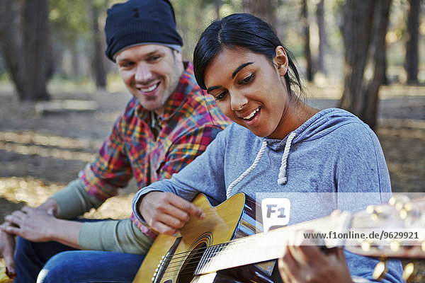 Junges Paar im Wald,  das Akustikgitarre spielt,  Los Angeles,  Kalifornien,  USA