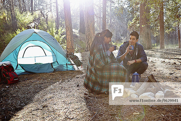 Junges Campingpaar trinkt Kaffee im Wald  Los Angeles  Kalifornien  USA