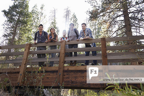 Portrait of five young adult friends on wooden bridge in forest  Los Angeles  California  USA