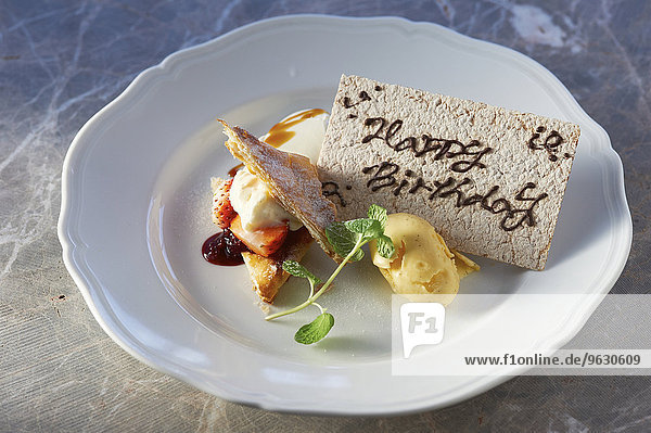 Birthday dessert plate with ice cream  sliced fruits and pastry