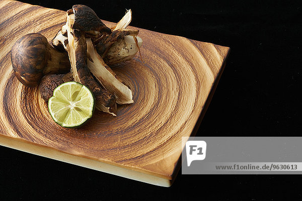 Mushrooms and lime slice on chopping board