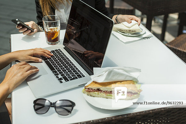 Businesswomen using laptop on working lunch