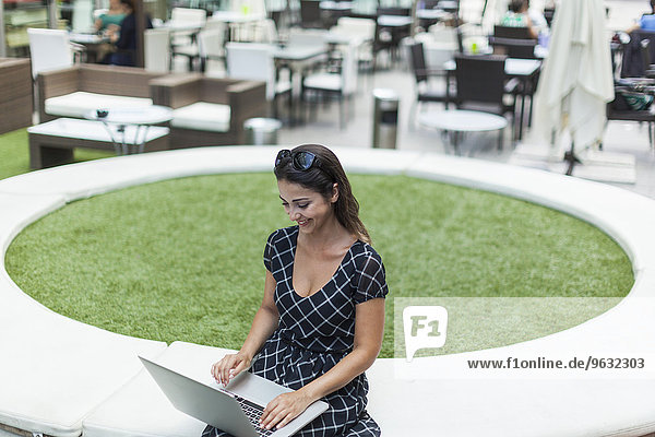 Frau mit Laptop von Outdoor-Cafe