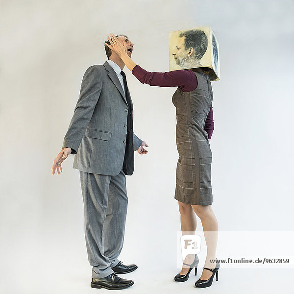 Businessman getting slapped by businesswoman wearing mask