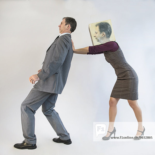Businessman being pushed by businesswoman wearing mask