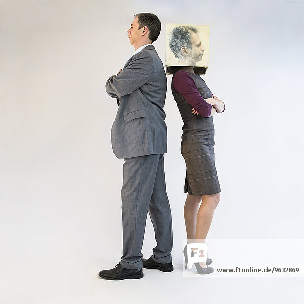 Businessman standing back to back of businesswoman wearing mask