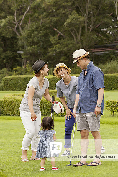 Family on a golf course.A child and three adults.
