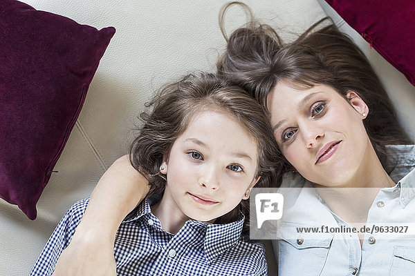 Portrait of mother and daughter lying on floor  smiling
