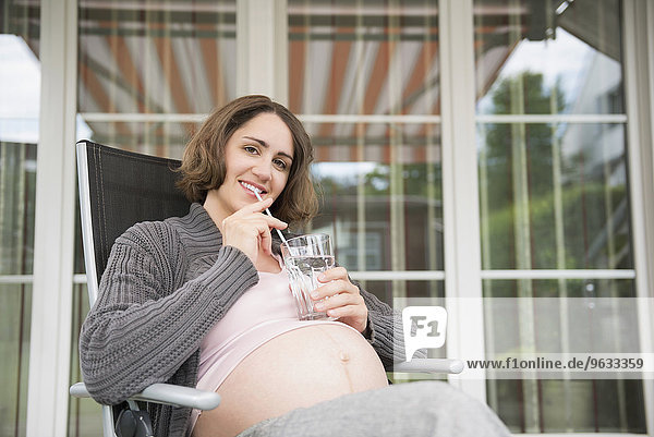 Portrait pregnant woman smiling drinking water