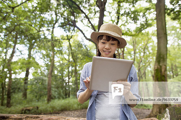 junge Frau junge Frauen halten Wald Tablet PC
