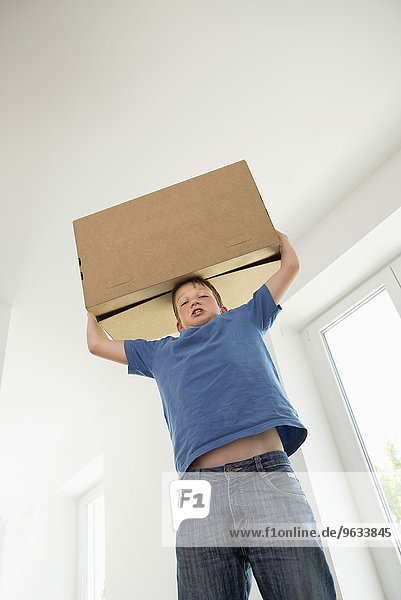 Boy carrying heavy box new room home