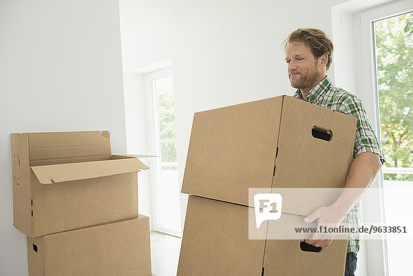 Moving in man carrying boxes new home
