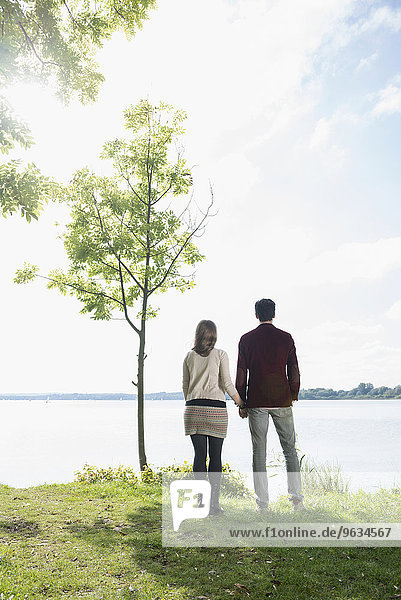 Couple holding hands lake shore romantic