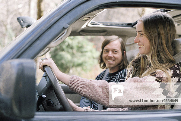 Smiling young couple driving in their car.