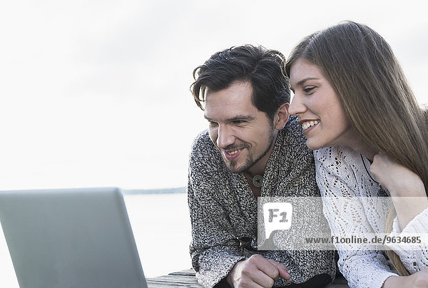 Young couple working laptop computer outdoors