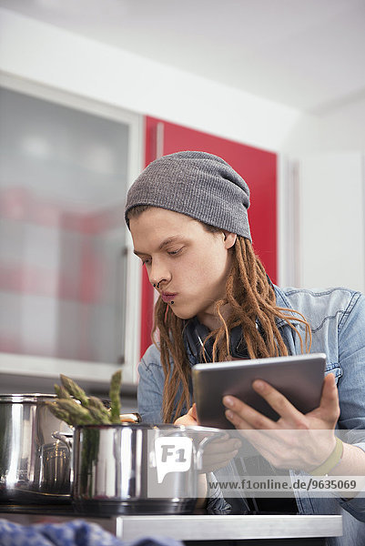 Young man looking at recipe on digital tablet