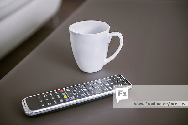 Remote control with coffee cup on table