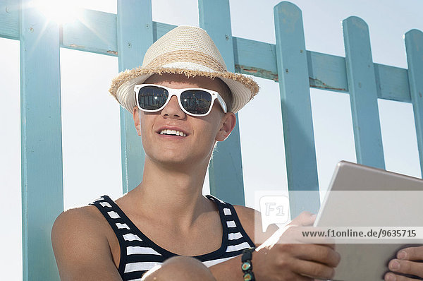 Teenage boy holiday beach summer tablet computer
