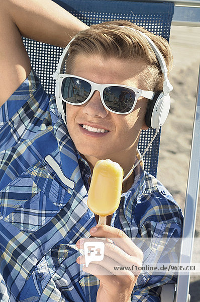 Boy holding ice cream beach sunglasses headphones