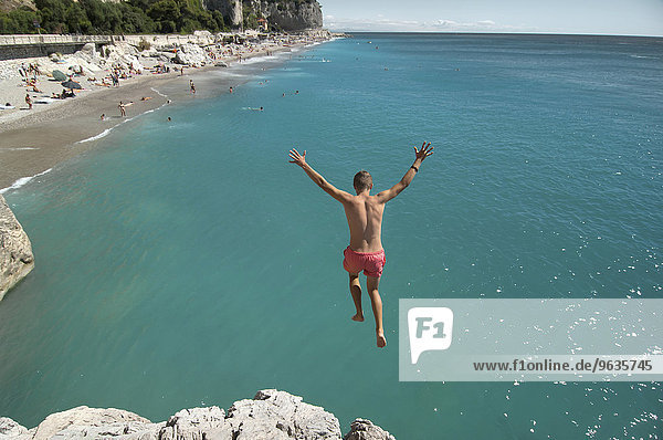 Boy holiday jump water ocean risk teenager