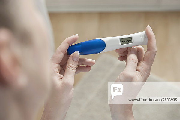 Close up woman holding positive pregnancy test
