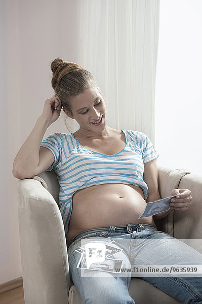 Young pregnant woman looking ultrasonic scan
