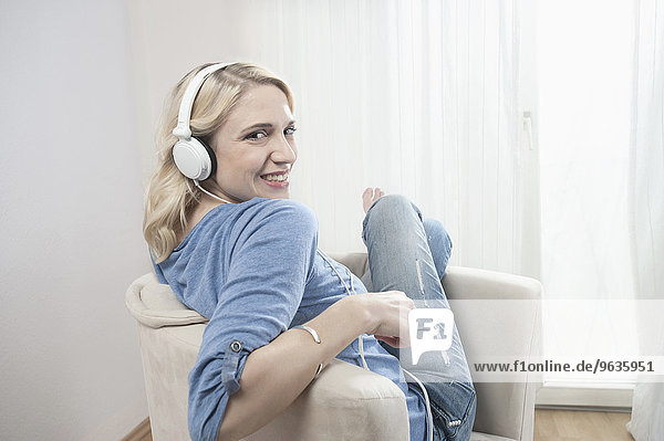 Woman sitting chair listening music headphones