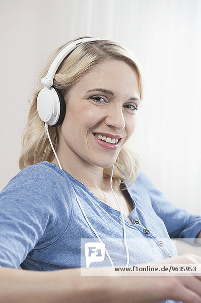Portrait woman sitting listening music headphones