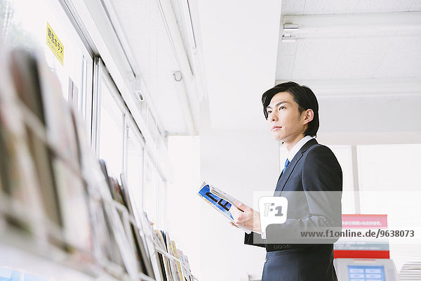 Junge japanische Geschäftsmann in einem Convenience-Store