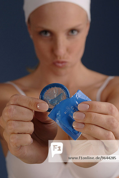 Junge Frau hat ein blaues Kondom in der Hand