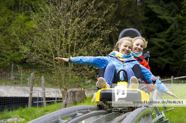 Junge Frauen auf einer Coasterbahn  Sommerrodelbahn  Steinwasenpark  bei Oberried  Schwarzwald  Baden-Württemberg  Deutschland  Europa