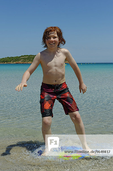 Junge surft mit seinem Boogie Board  Beach Board oder Skimboard am Strand  Bucht von Rondinara  Südostküste  Korsika  Frankreich  Europa